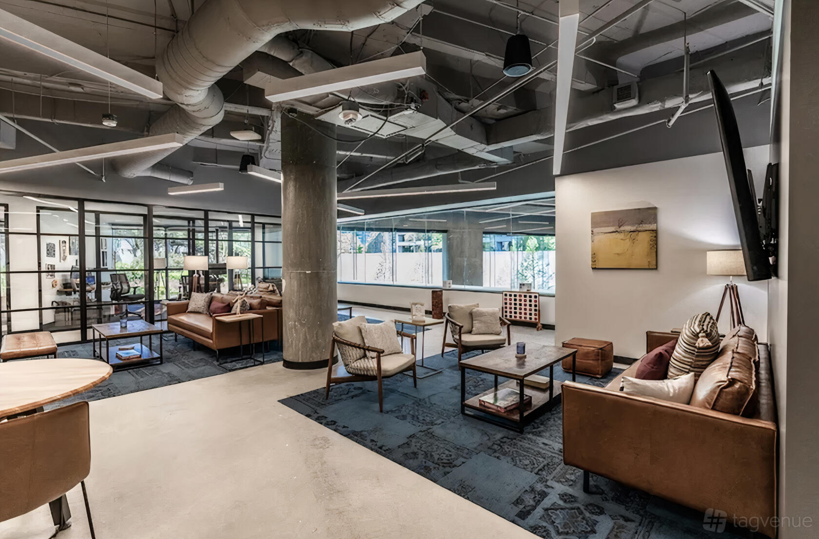 An event venue with leather sofas, armchairs, exposed concrete pillars, and large windows at Buckhead.