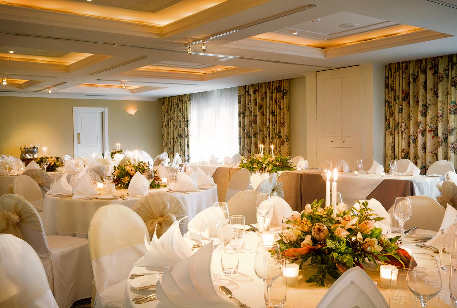 A banqueting hall with round tables, white linens, floral centerpieces, and draped curtains at Lilianfels Resort & Spa.
