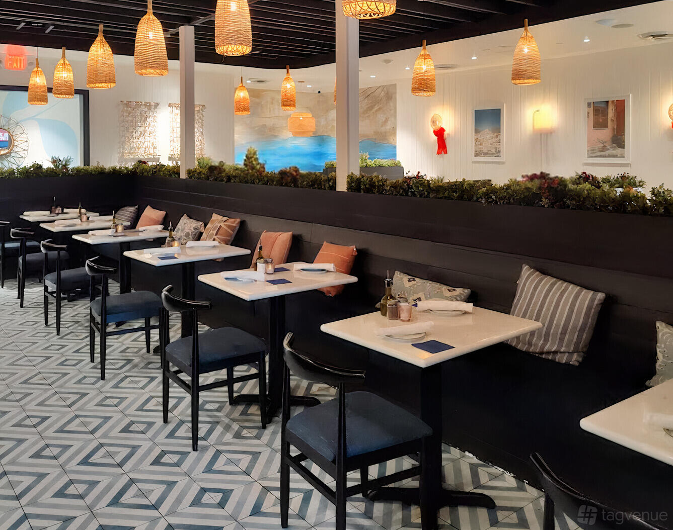 A dining room with marble tables, black chairs, patterned tile floor, and wicker pendant lights at Our Mom Eugenia - Mosaic District.