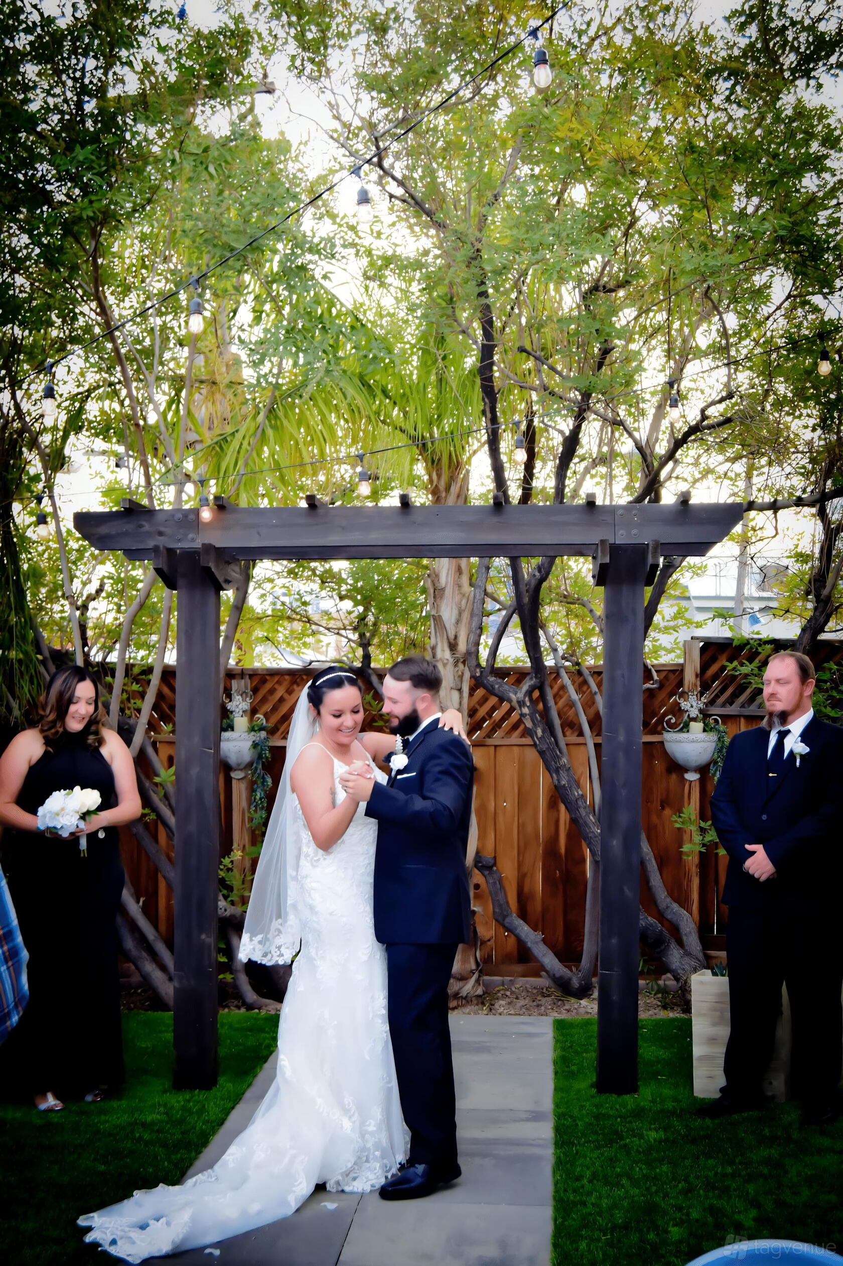 An outdoor wedding space with a wooden gazebo, leafy trees, and a wooden fence at Mon Bel Ami Wedding Chapel.