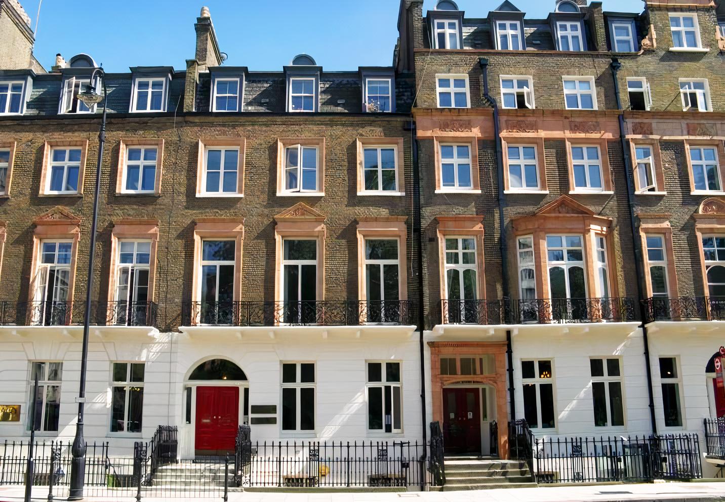 A conference centre with Victorian brick facade, arched red doors, and tall sash windows at De Morgan House.