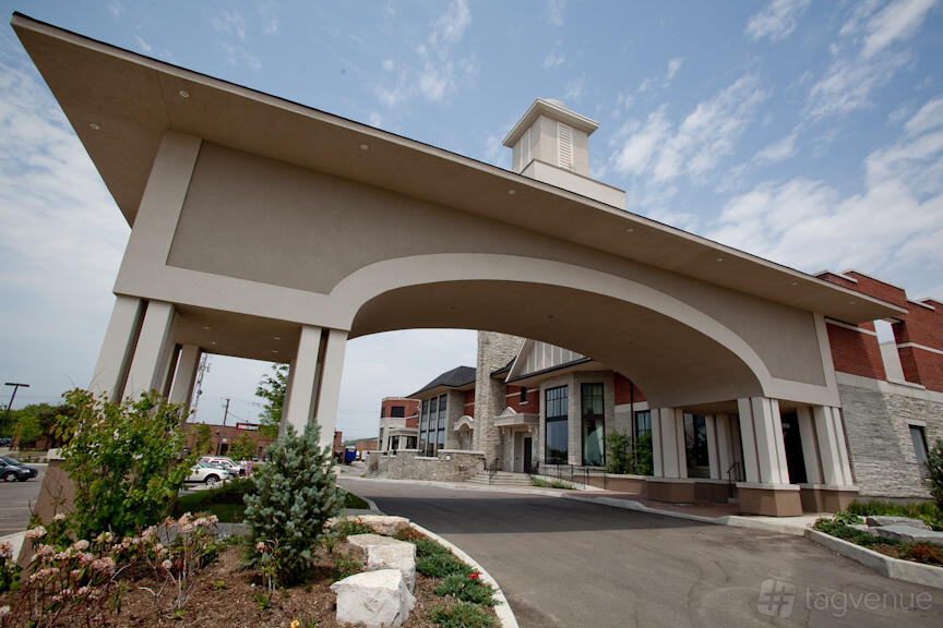 A versatile event space with a grand porte-cochère entrance, stone accents, and landscaped gardens at Hazelton Manor.