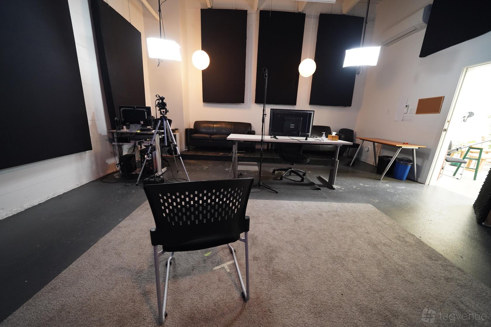 A photo and film studio with acoustic panels, studio lighting, and a workspace setup at Shoreline Studios.