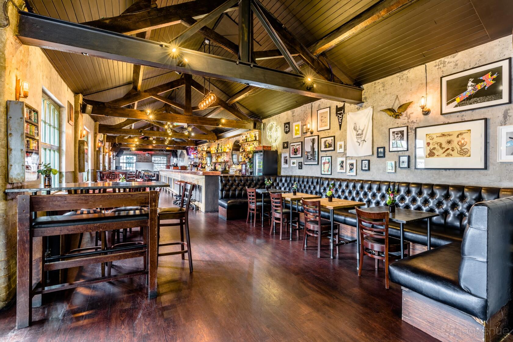A bar with exposed wooden beams, tufted leather banquettes, and framed artwork at Lockside and 180 Club Camden.
