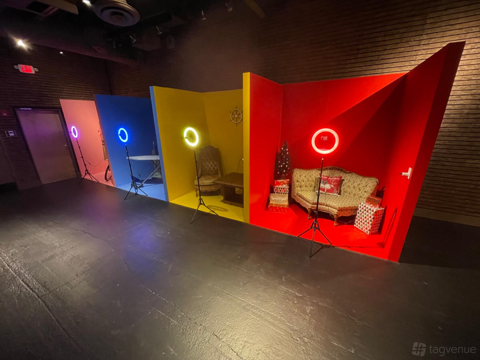 A photo studio with four colorful portrait booths, each with a ring light and unique seating at Illimite Studio.