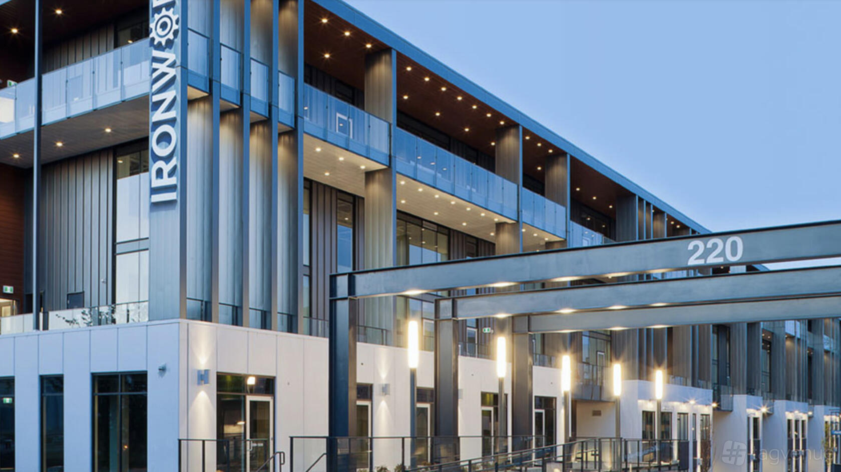 A modern film and photo studio with glass balconies, metal beams, and exterior lighting at Tangible Studio.