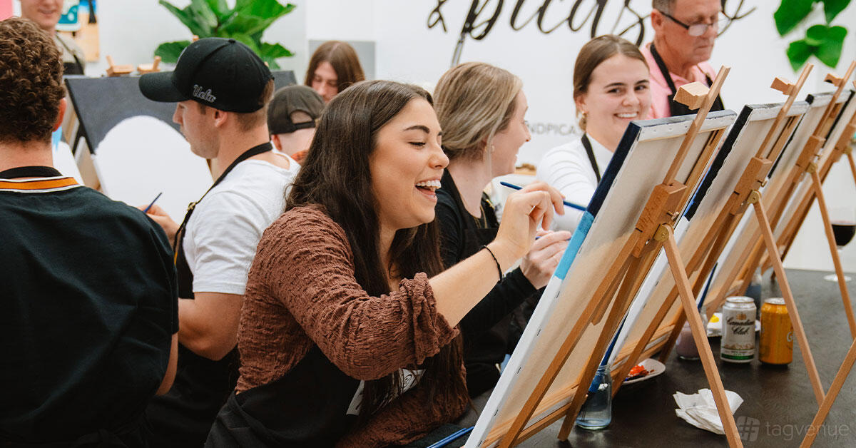 An event venue with guests seated at easels painting on canvases at Pinot & Picasso Redcliffe.