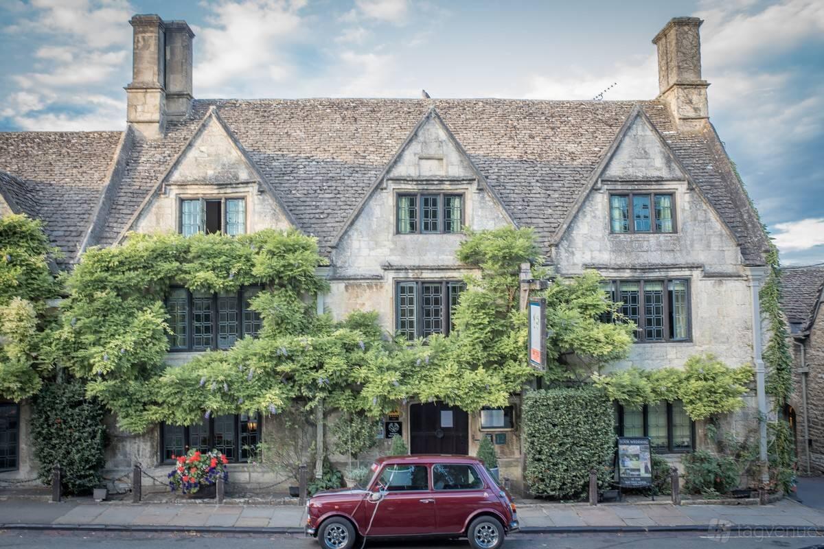 A stone-built hotel with gabled roofs, ivy-covered facade, and classic windows at The Bay Tree Hotel.