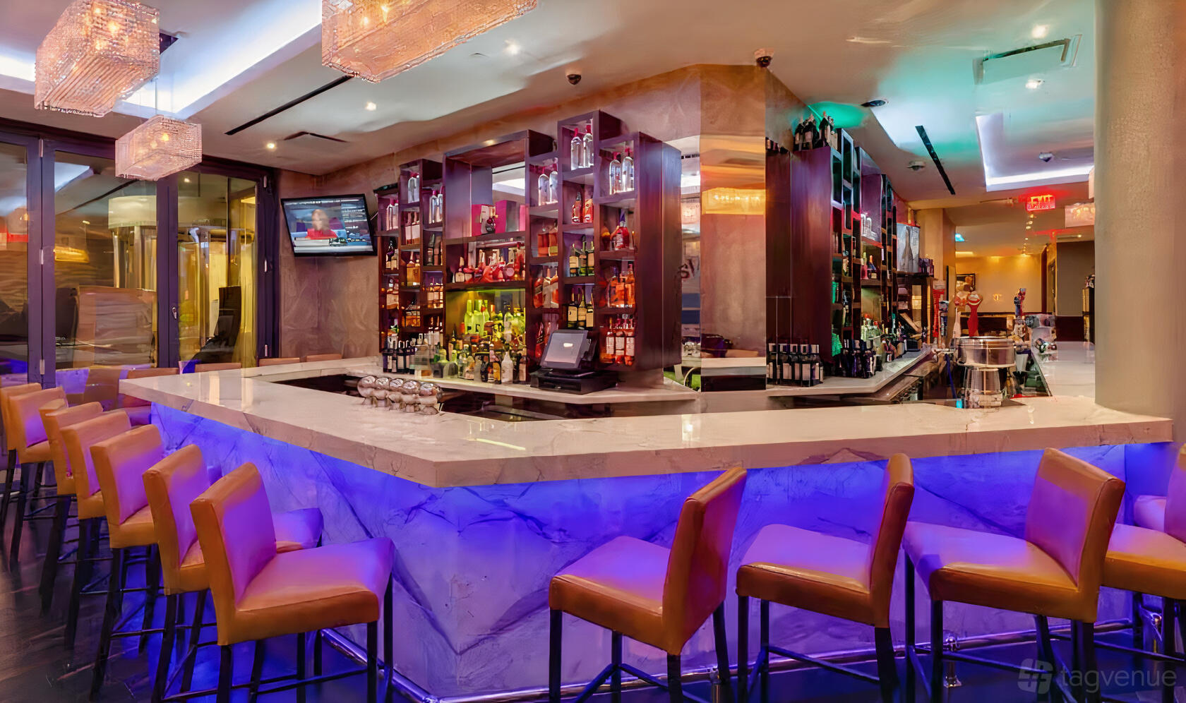 A restaurant lounge with a marble-topped bar, purple underlighting, and leather barstools at Empire Steak House West.