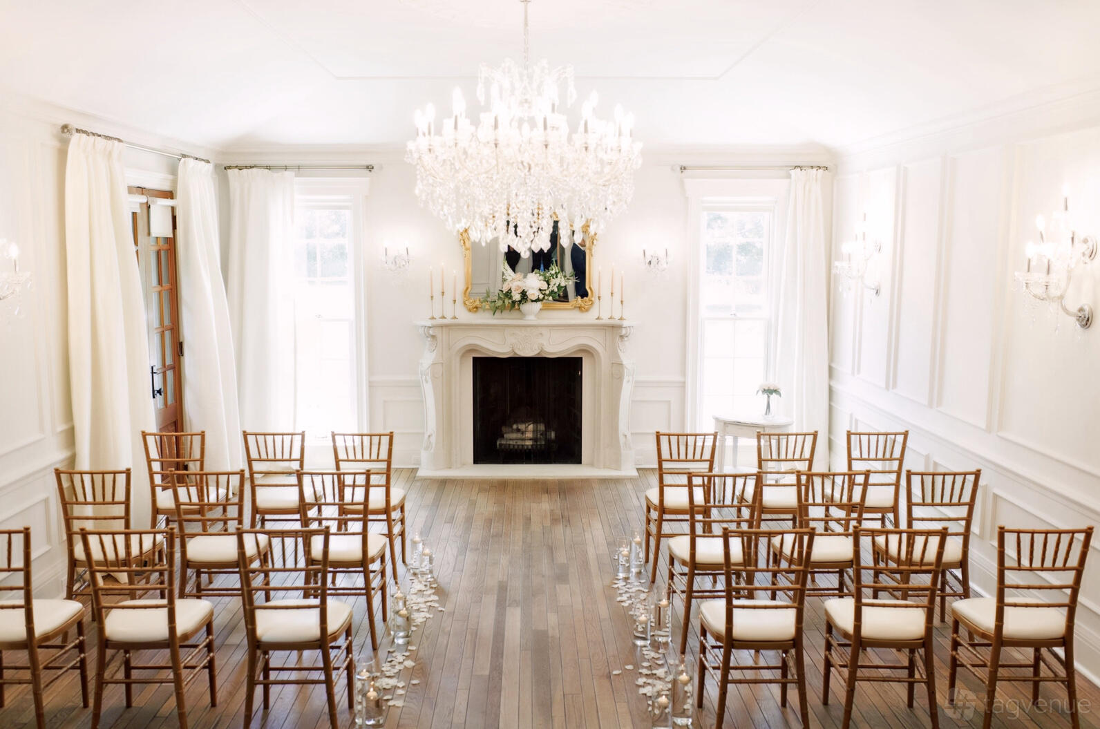 A historic building with crystal chandeliers, white walls, and a decorative fireplace at The Ruby Manor.
