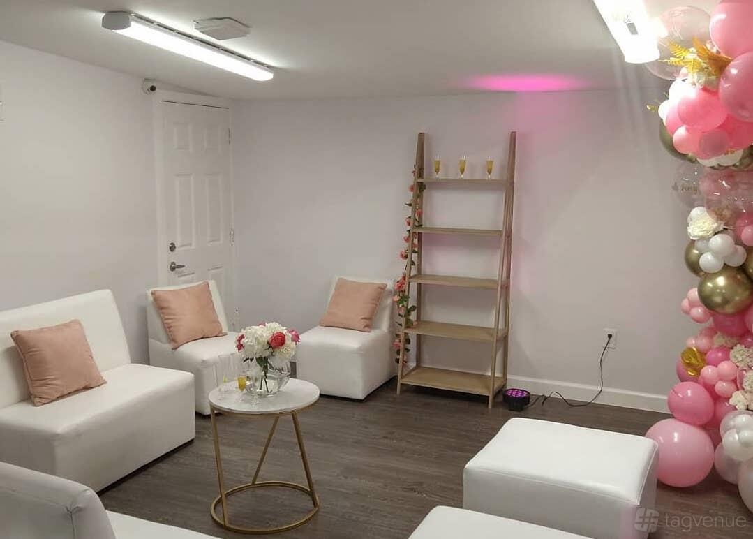 An event venue with white lounge chairs, blush pillows, floral decorations, and a balloon arch at CT's Creative Art Space Medical Center.