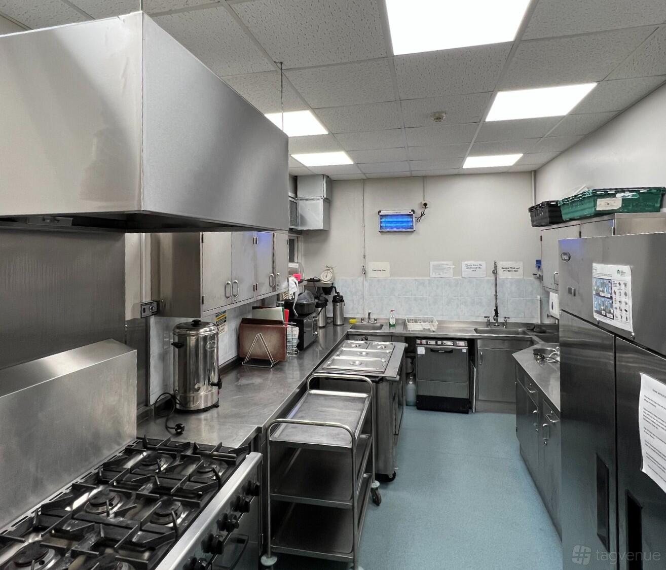A church kitchen with stainless steel countertops, gas stove, sinks, and commercial appliances at West Croydon Baptist Church.