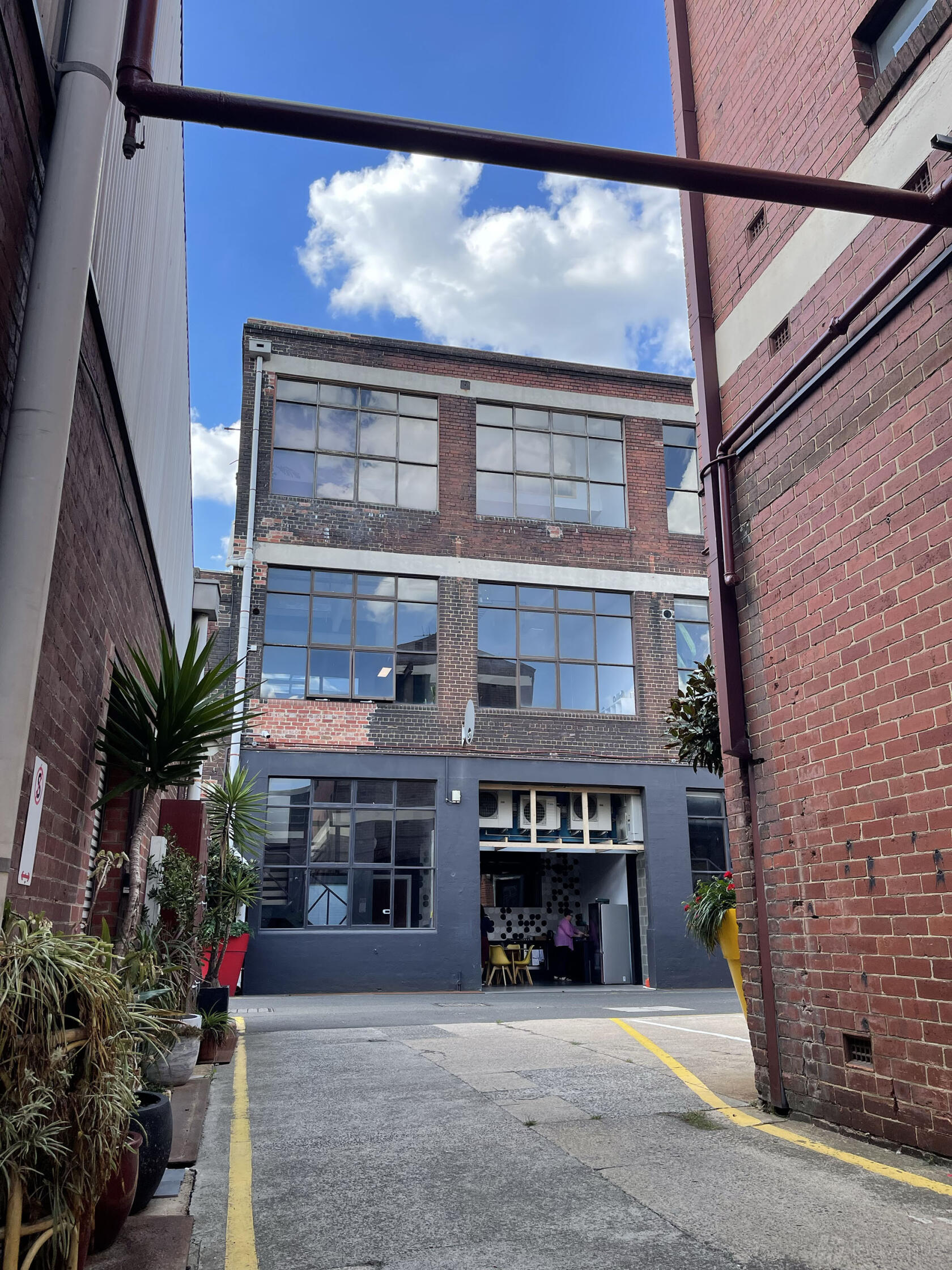 A film and photo studio with large industrial windows and exposed brick facade at Glow Studios G37.