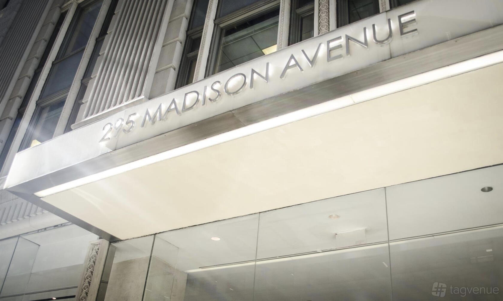 A meeting centre entrance with large glass doors and a sign reading 295 Madison Avenue at Helix Workspace.