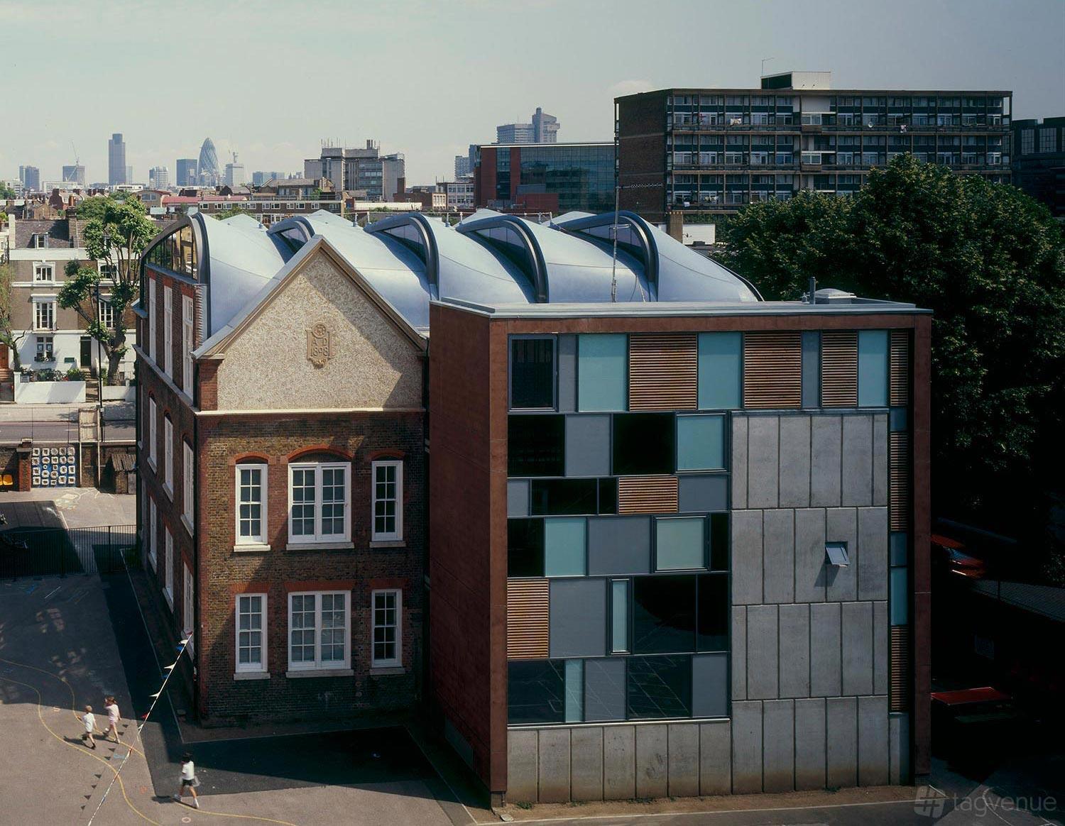 A modern event venue with curved rooftop windows and a mix of glass and brick facade at Siobhan Davies Dance Studios.