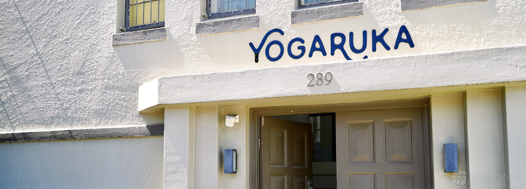 A hall entrance with cream-painted walls, large double doors, and blue window accents at Yogaruka - Drummoyne.