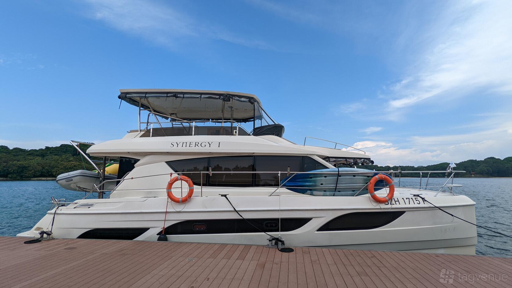 A docked boat with upper deck seating, lifebuoys, and tinted windows at One 15 Marina.