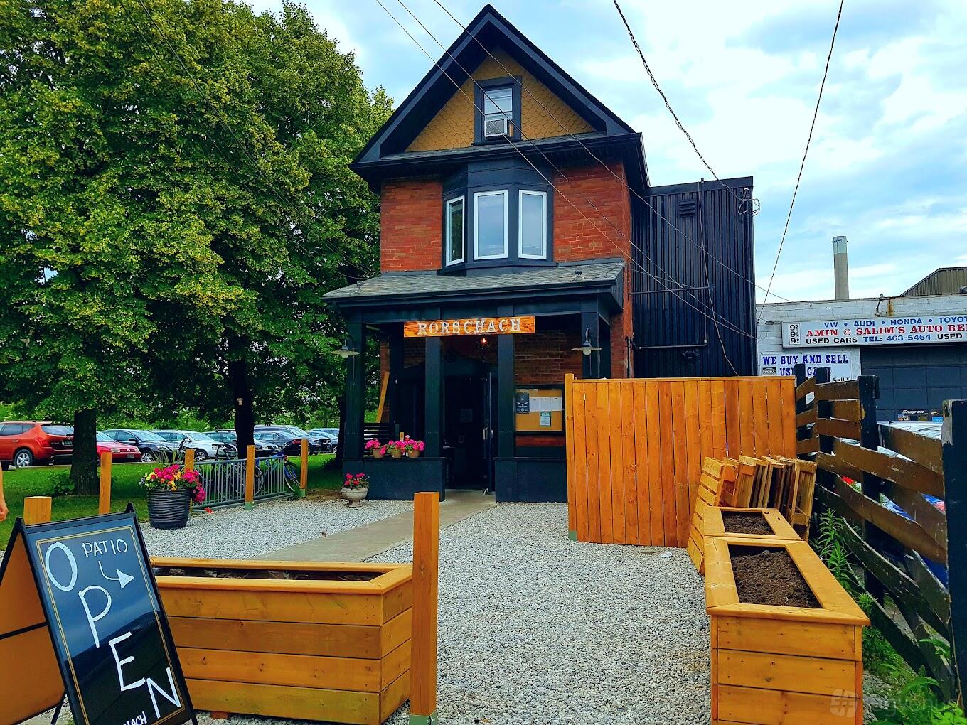 A pub with a wood-paneled exterior, gravel patio, and planter boxes at Rorschach Brewing Co.