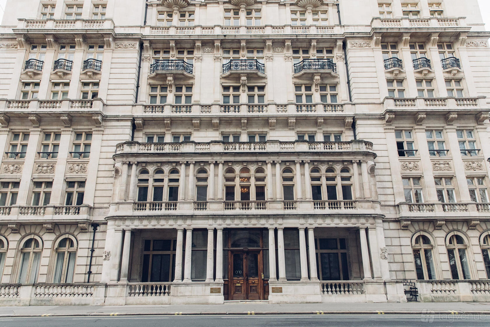 A historic building with ornate stonework, arched windows, and wrought iron balconies at Huckletree Public Hall.
