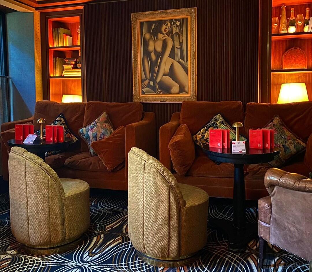 An event space in a cocktail bar with velvet sofas, round tables, and bookshelves at 9 Below.