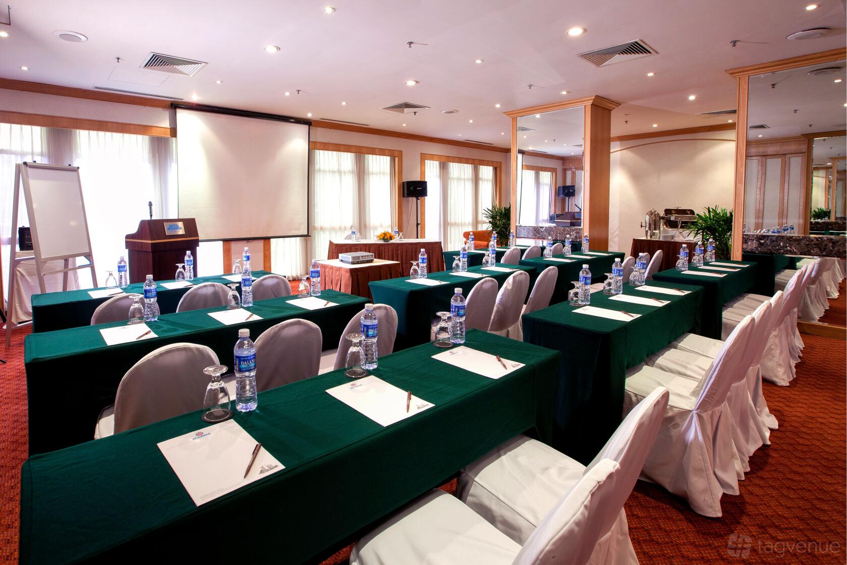 A function room with classroom-style seating, covered chairs, and natural light at Hotel Miramar Singapore.
