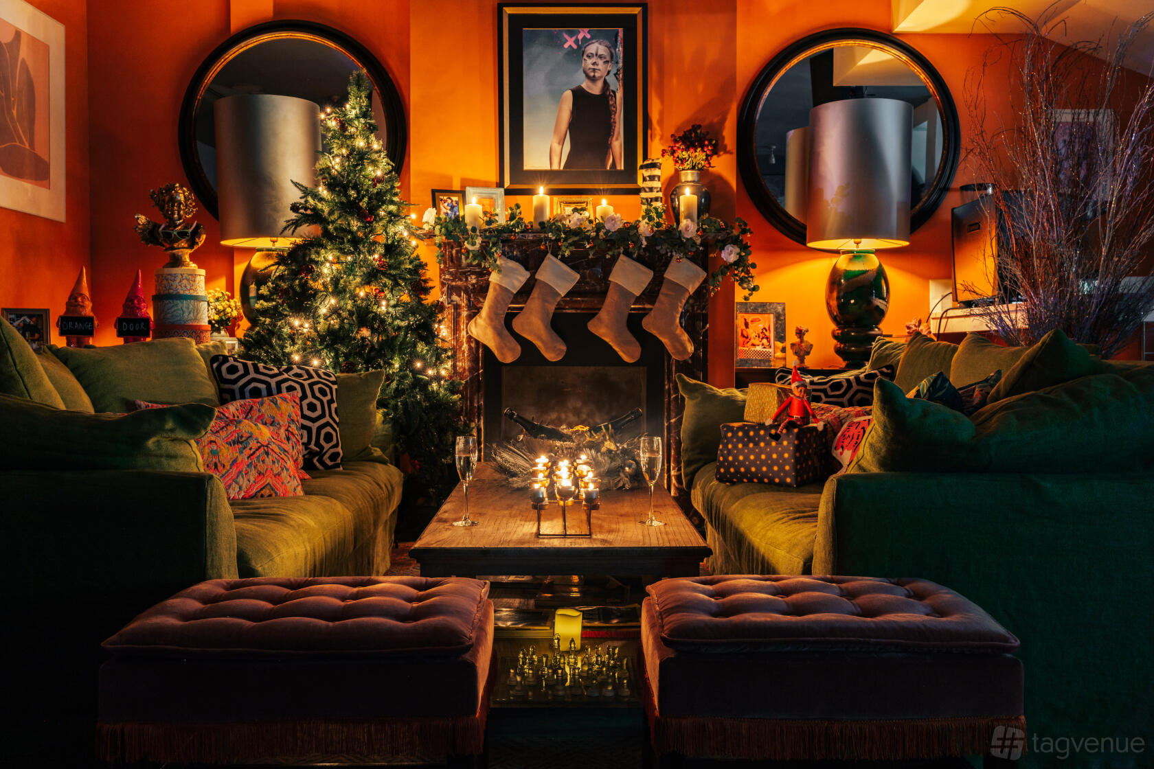 A cocktail bar with cozy velvet sofas, a decorated fireplace, and warm orange walls at The Little Orange Door.