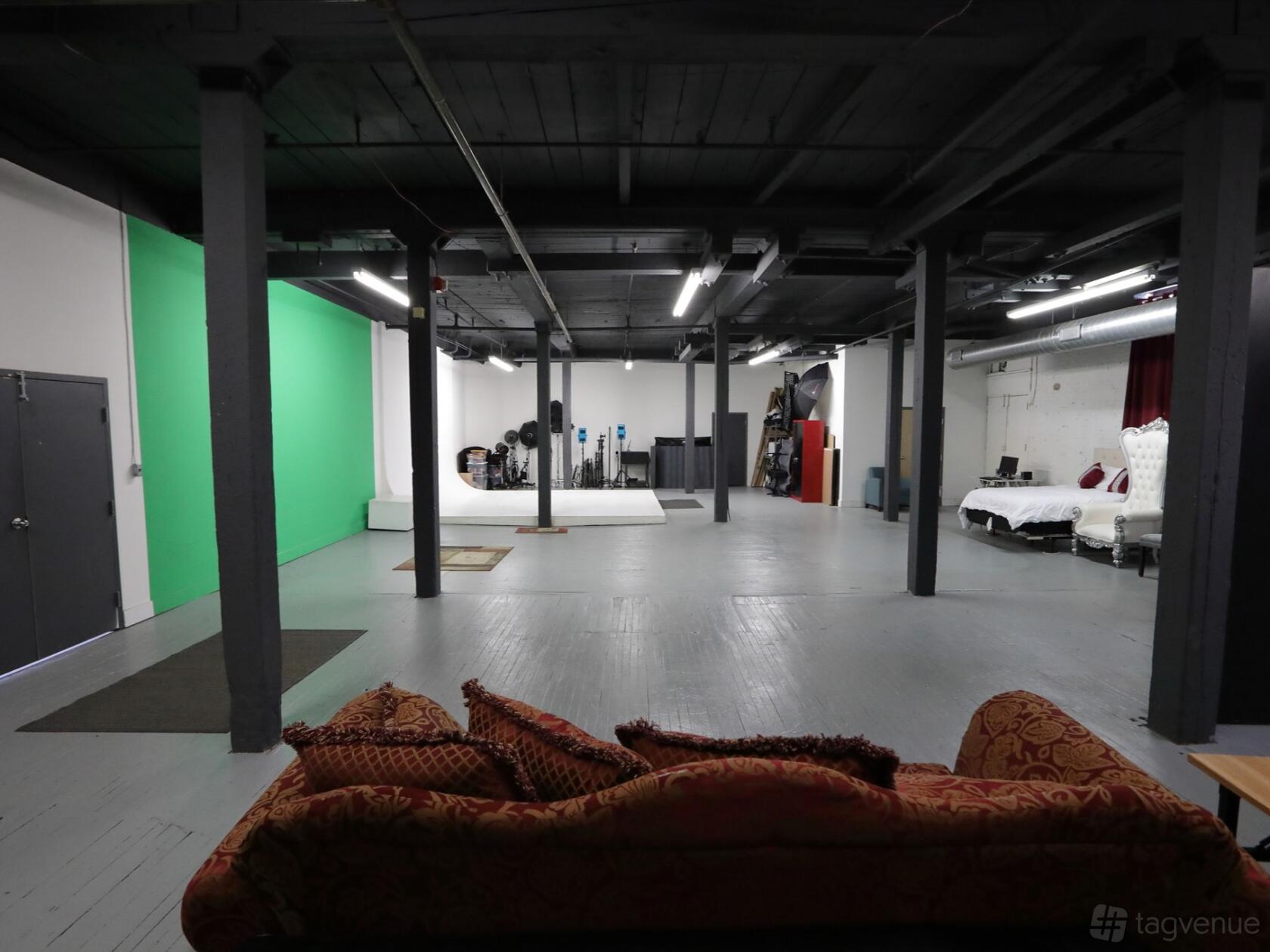 A photo studio with a green screen, photography backdrops, softbox lights, and an open shooting area at Studio 2e.