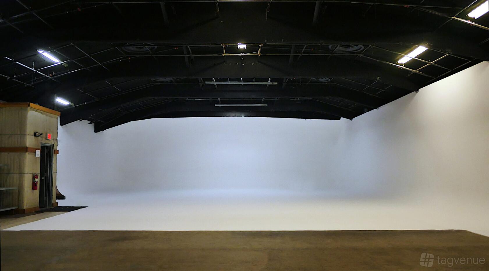 A photo studio featuring a large cyclorama wall and high black ceiling at BLT STUDIOS.