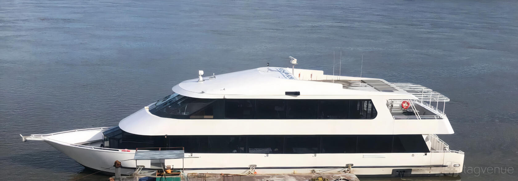 A yacht with large tinted windows docked by the water at Jerico Yacht Charters.