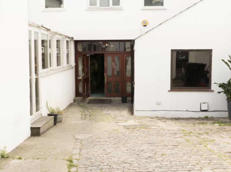 A film and photo studio with a cobblestone courtyard and glass entry doors at Apiary Studios.