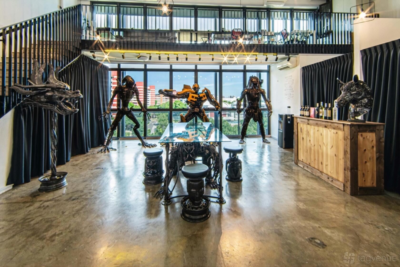 An art gallery with large windows, polished concrete floors, and metal sculptures at Stal Pte Ltd.