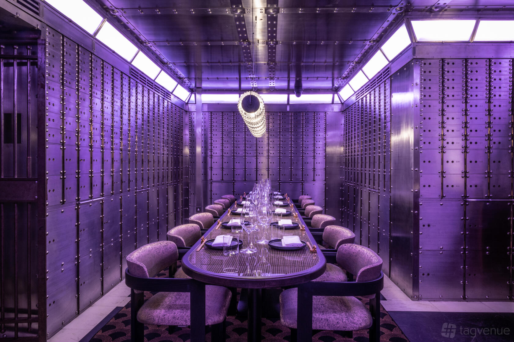 A private dining room with metallic vault walls, purple ambient lighting, and a long table at Lucky Cat - Manchester.