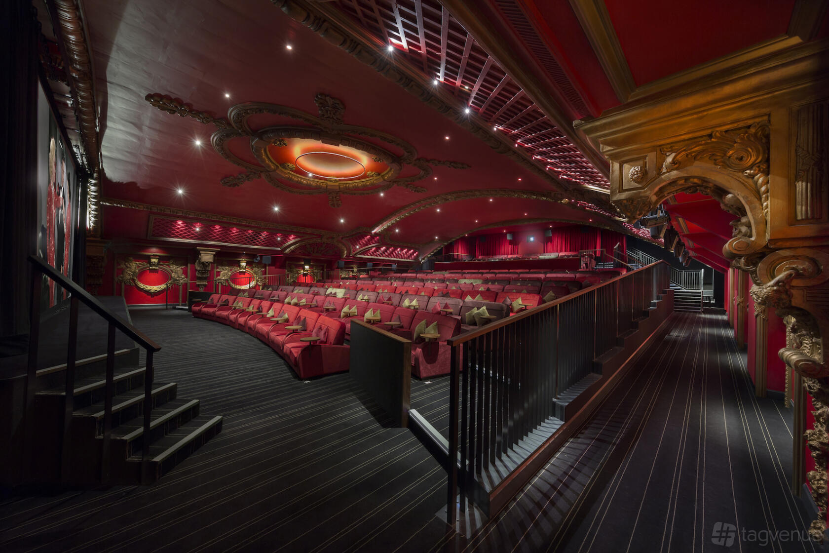 An auditorium with tiered red velvet seats, ornate ceiling details, and ambient lighting at Everyman Bristol.