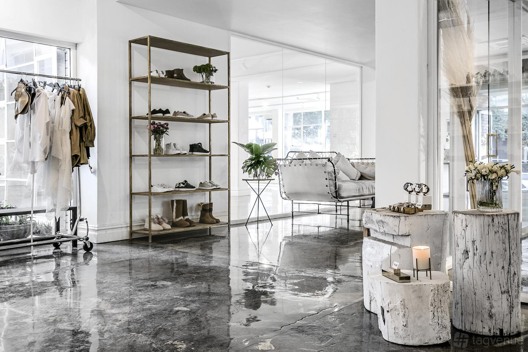 An event venue with polished concrete floors, a metal shelving unit, and lounge seating at La Porte Space.