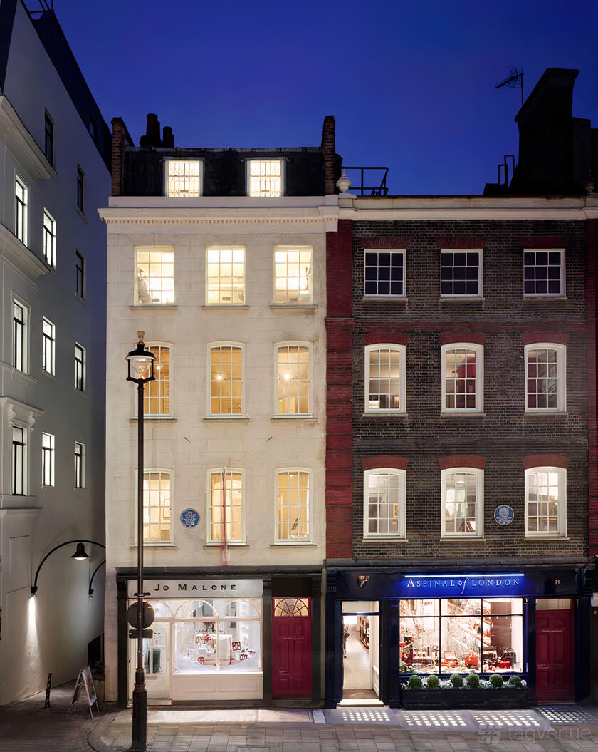 A historic museum exterior with lit sash windows and brick facade at Handel Hendrix House.