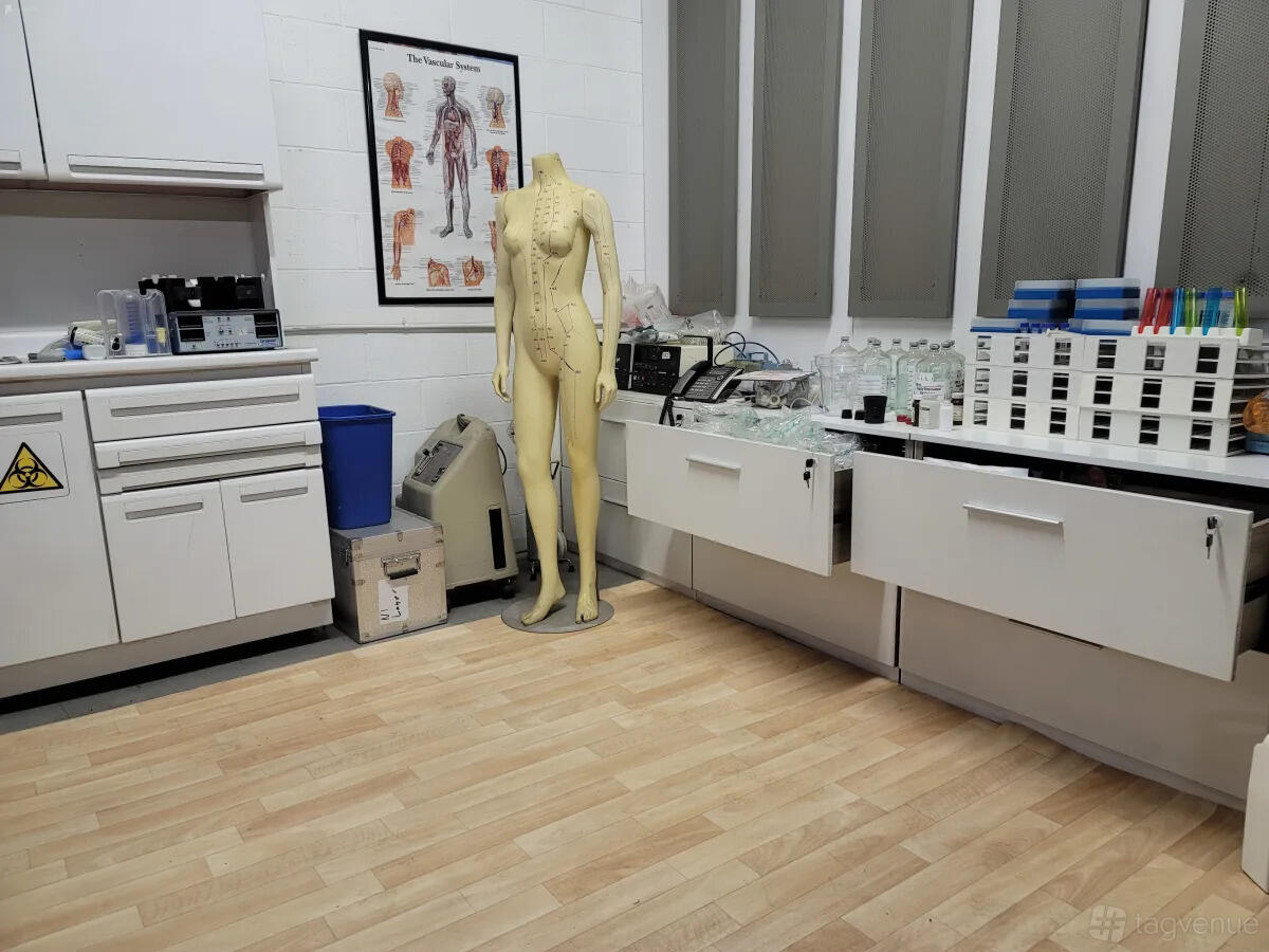 A photo studio with medical lab props, anatomical mannequin, lab glassware, and specimen racks at Cosmic Cube Creative Studio.