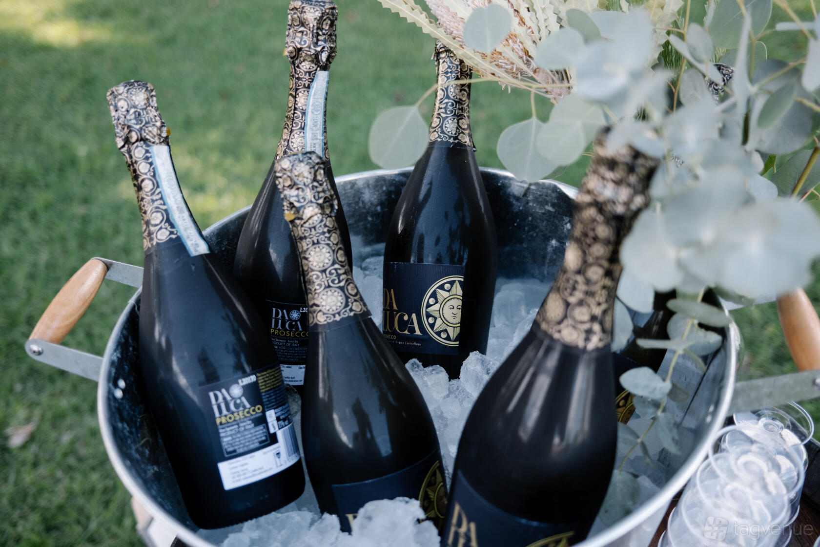 A cafe with a large metal bucket of chilled sparkling wine bottles on ice at The Marina - Cafe & Bar.