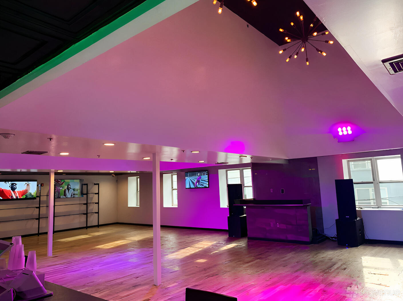 An event hall with wood flooring, accent lighting, windows, and a small bar at EGO HALL.