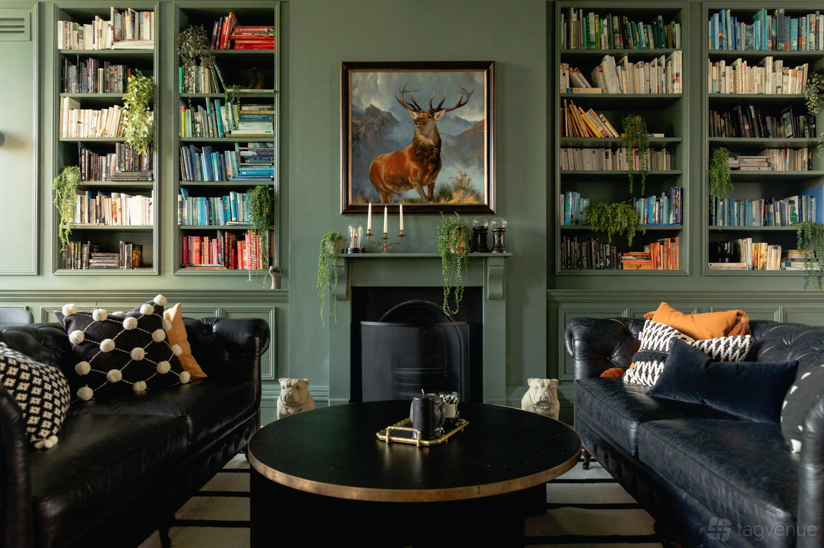 An event venue with built-in bookshelves, a fireplace, and leather sofas at Kindred