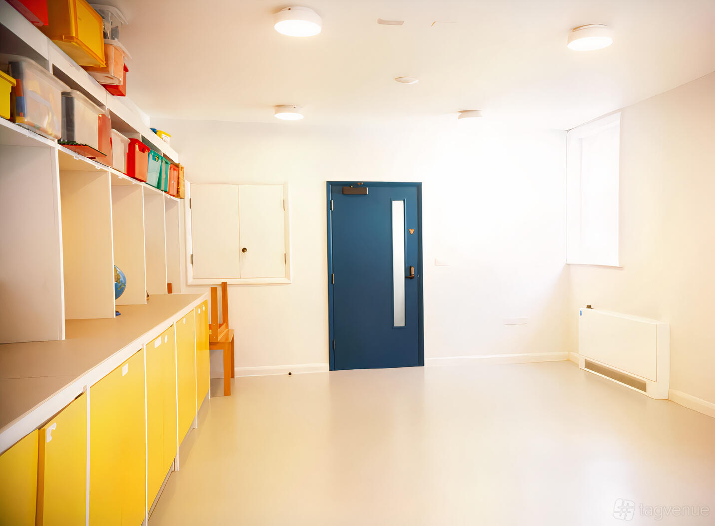 A function room with yellow cabinets, open shelving, and blue door at Longfield Hall