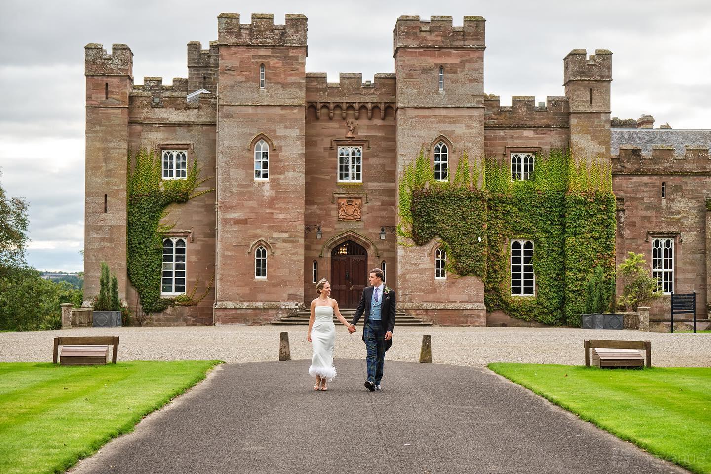 A historic building with a grand stone facade, battlements, arched windows, and ivy at Scone Palace.