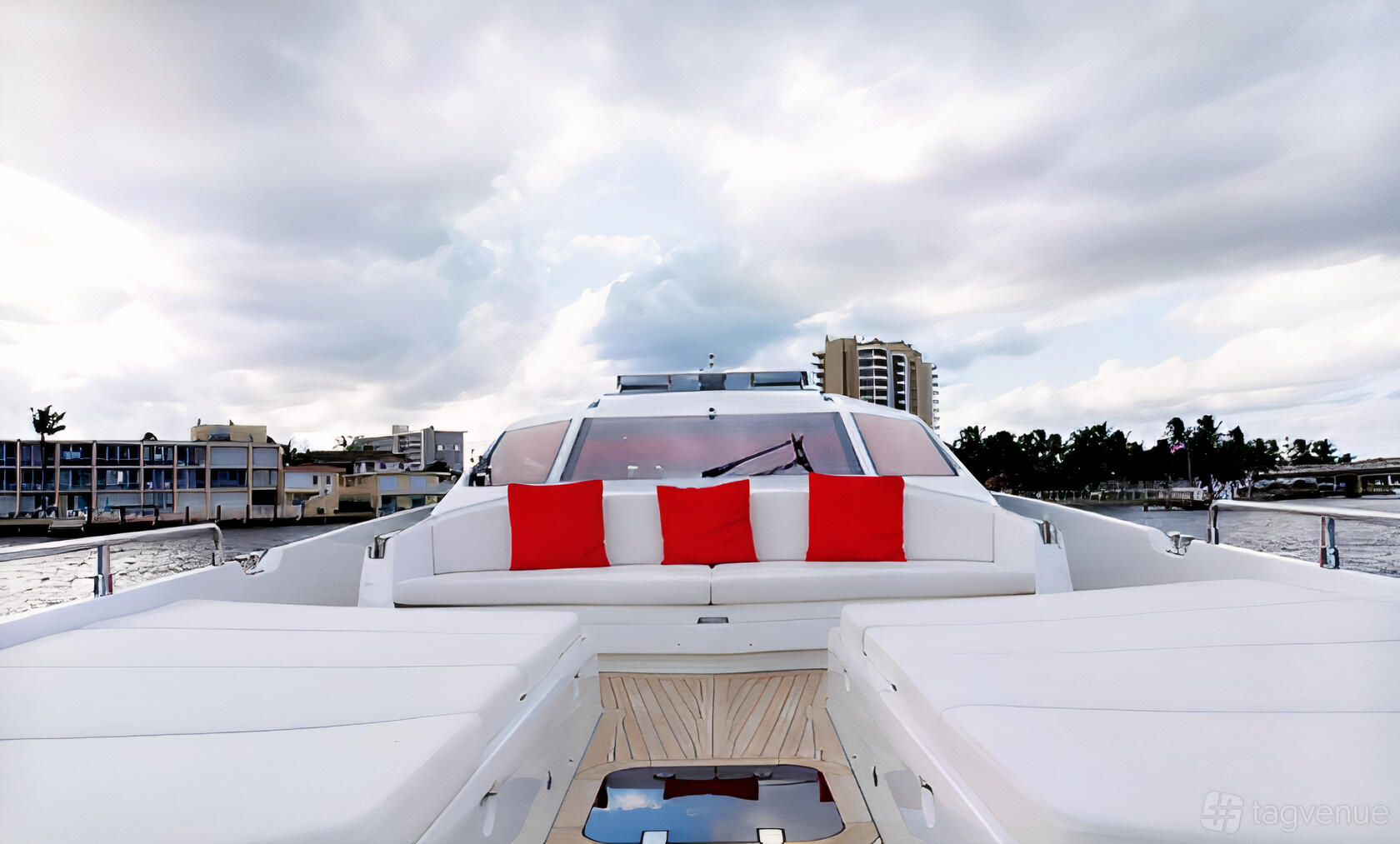 A boat deck with white cushioned seating, red accent pillows, and waterfront views at Terrific Boat Charters.