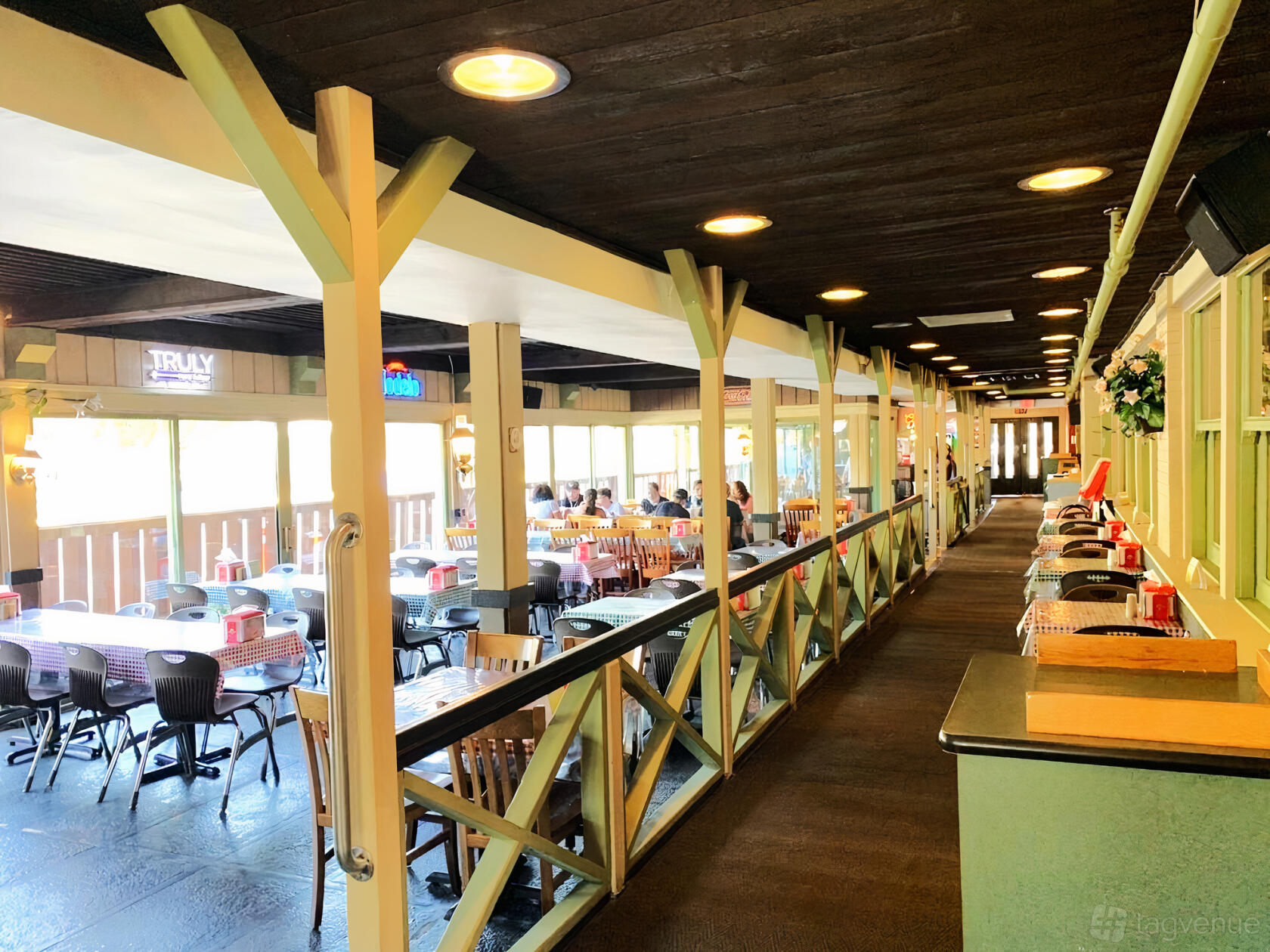 An outdoor restaurant patio with a covered roof, wood beams, and picnic tables at Russell's Barbecue.