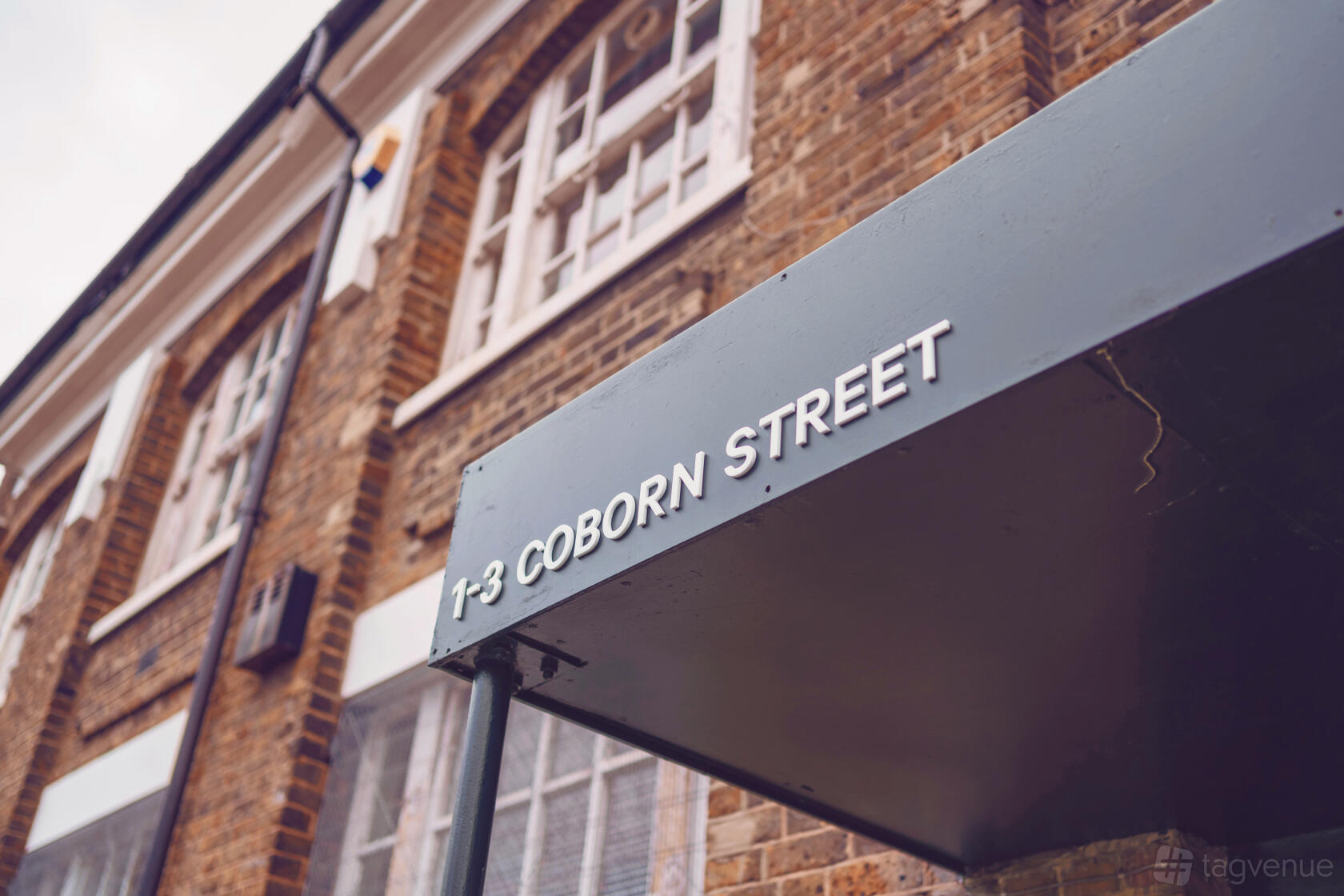 A versatile event space with a brick exterior and entrance canopy displaying the address at 1-3 Coborn Street.