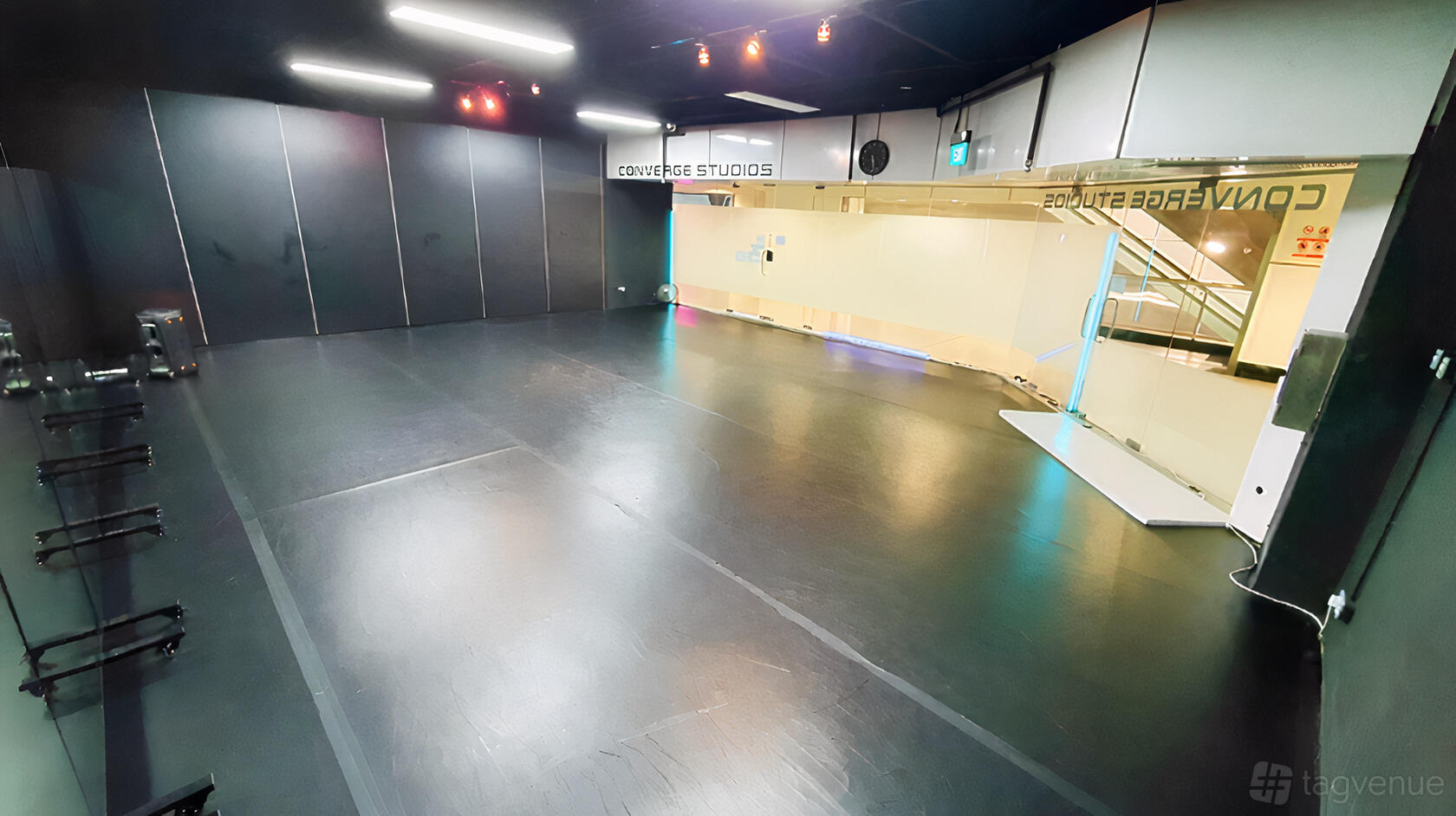 A dance studio with mirrored walls, black flooring, and bright overhead lighting at Converge Studios Dhoby Ghaut MRT.