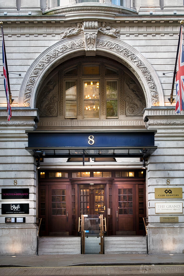 An event space entrance with ornate stone archway, hanging lights, and double wooden doors at 8 Northumberland Avenue.