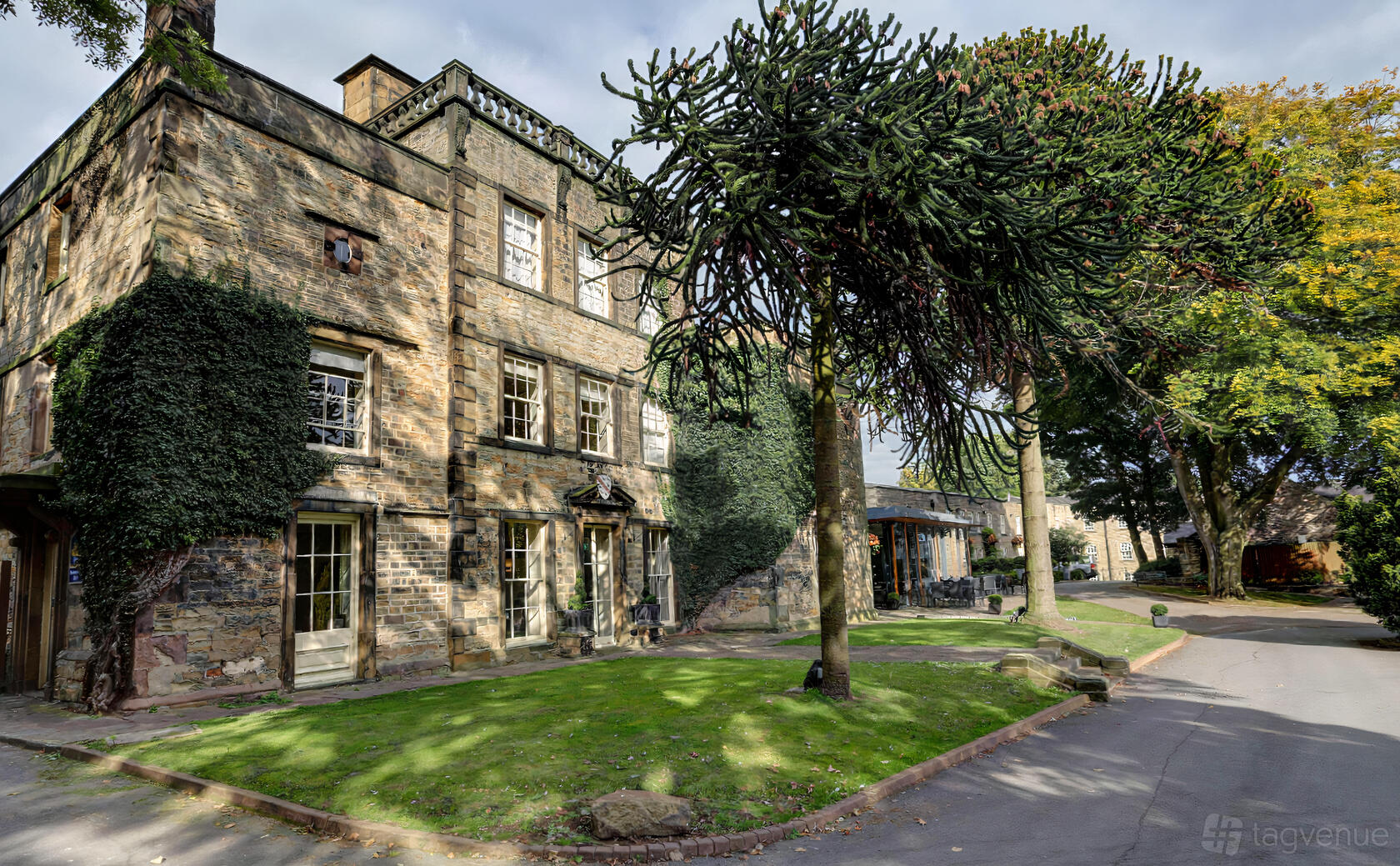 A historic hotel with ivy-covered stone walls and mature trees at Mosborough Hall Hotel.