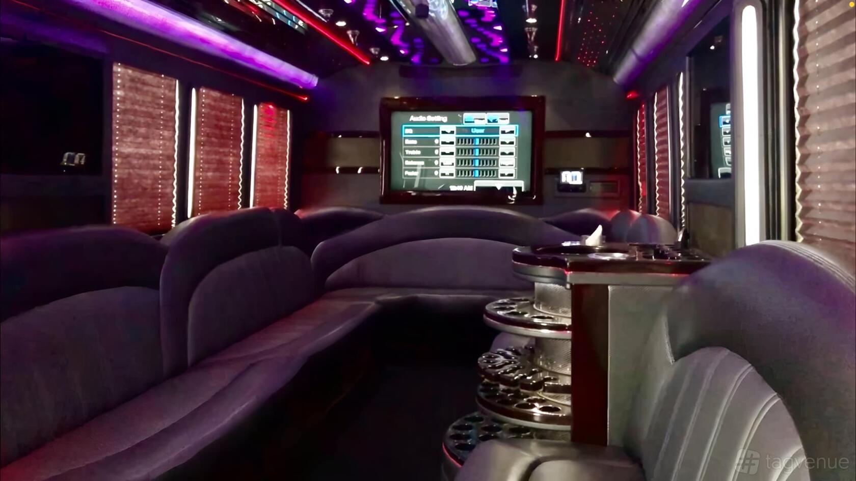 A party bus with wraparound leather seating, disco lighting, and a large TV screen at AB Limousine Services.