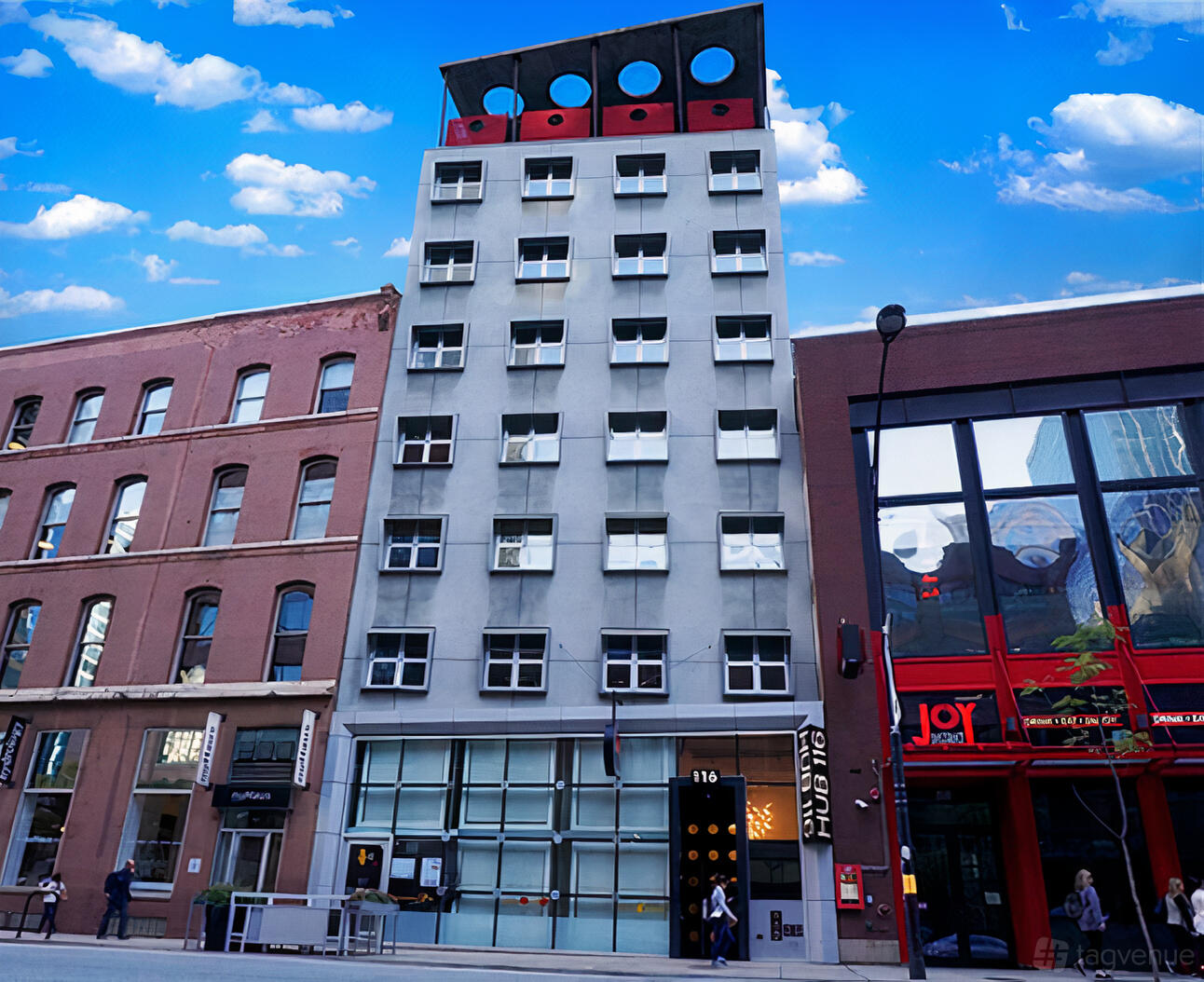 A meeting centre with a modern gray facade, multiple rows of windows, and street-level entrance at Hub116.