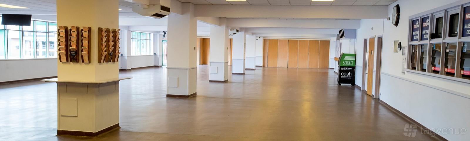 An event venue with open-floor space, white columns, large windows, and wooden partition walls at Wolverhampton Racecourse.
